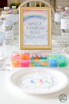 there is a sign that says make a rainbow bead necklace next to some candy