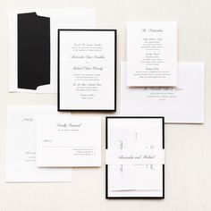 the wedding stationery is laid out on top of each other, with black and white paper