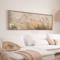 a living room with white couches and large painting on the wall above it's headboard