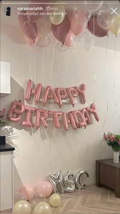 balloons and streamers in the shape of happy birthday letters are hanging from the ceiling