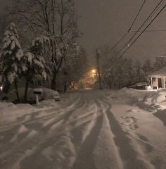 a street covered in snow next to a house