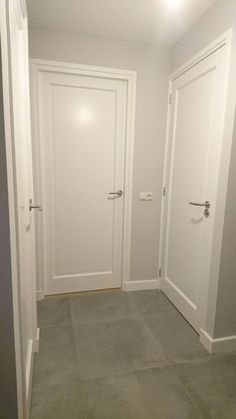 an empty room with two white doors and no one in the room or there is something on the floor