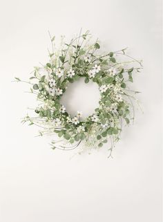 a wreath with white flowers and green leaves