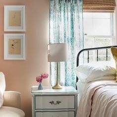 a bedroom with pink walls and white furniture