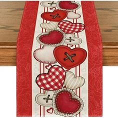 a red and white table runner with hearts on the border, one has crosses in it