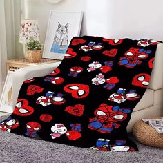 a black blanket with red, white and blue cartoon characters on it sitting next to a chair