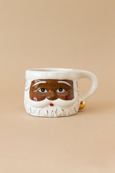 a ceramic mug with a face painted on it