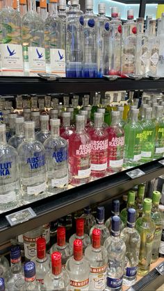 many bottles of alcohol are lined up on the shelf