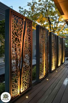 an outdoor area with wooden flooring and metal screens on the wall, along with trees