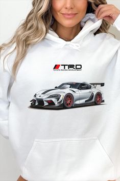 a woman wearing a white hoodie with the image of a sports car on it