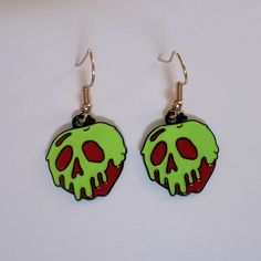 a pair of earrings with a green and red skull on it's earring hooks