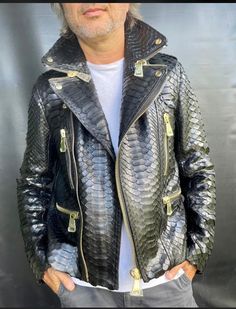 Step into the realm of luxury and style with our King Snakeskin Biker Jacket for men.  Meticulously handcrafted using genuine King python leather, this jacket exudes sophistication and exclusivity. With its glossy finish and the largest flakes among all python leather types, it stands as a rare and prized piece in the fashion world. Our dedication to premium quality is evident in every stitch and detail of this jacket. The golden accessories from SERGIO STEFANO, Italy, further enhance its luxurious appeal, adding a touch of refinement to your ensemble. Elevate your fashion statement with this remarkable biker jacket. Experience the epitome of luxury and style as you embrace the exclusive allure of our King Snakeskin Biker Jacket.  Make a statement that is as unique as it is sophisticated. Luxury Snake Print Outerwear For Fall, Luxury Biker Jacket For Fall, King Dragon, Jacket For Man, Leather Jacket For Men, Black Python, Interesting Ideas, Crocodile Leather, Jacket For Men