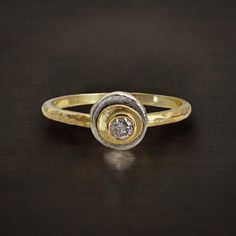 a gold and diamond ring sitting on top of a table