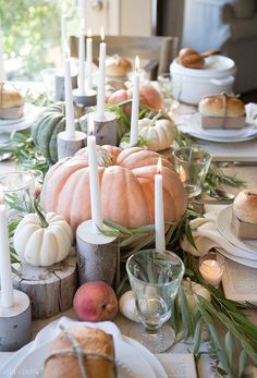 the table is set with pumpkins and candles