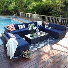 a couch and table on a deck next to a swimming pool with the phi villa logo above it