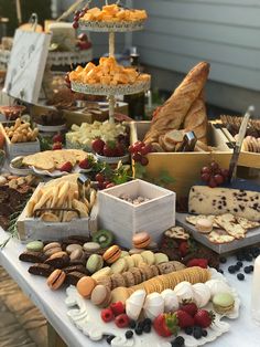 a table topped with lots of different types of food and desserts next to a building