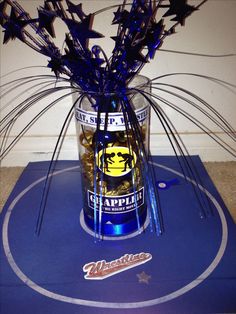 a glass vase filled with purple flowers and blue straws on top of a table