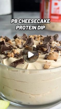 a cake with white frosting and chocolate chips on top that says pb cheesecake protein dip