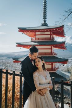 a bride and groom pose for a photo in front of the pagodas at their wedding