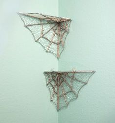 two metal spider webs hanging on the wall