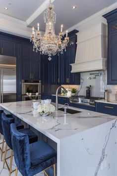 a large kitchen with blue cabinets and marble counter tops