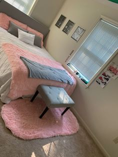 a bedroom with a bed, window and pink rug