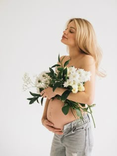 a pregnant woman holding flowers in her stomach