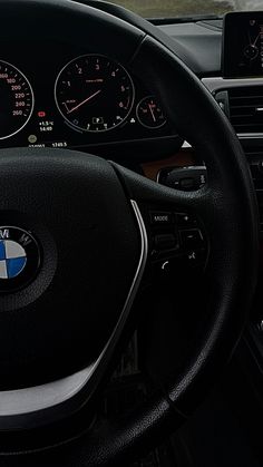 the steering wheel and dashboard of a bmw car