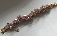 "Delizza and Elster, Juliana design with pink rhinestones and givre lavender satin glass teardrop accents. Beautiful, sparkling diamond like gems on this lovely link bracelet with a gold finish. A larger pink chaton is on a link that links two other ornate gem clusters. A total of five clusters and six large gem connectors. There is a chain guard as well as the very secure clasp. Wear this lovely bracelet on your fanciest outing. Quite a stunning and rare Juliana by Deliza and Elster from their Pink Sparkling Stones Bracelet For Wedding, Pink Wedding Bracelets With Sparkling Stones, Pink Crystal Bracelet With Rhinestones, Pink Crystal Bracelet For Formal Occasions, Pink Crystal Bracelets For Formal Occasions, Formal Pink Crystal Bracelet, Pink Crystal Bracelet With Sparkling Stones For Party, Elegant Pink Crystal Bracelet With Sparkling Stones, Elegant Pink Jeweled Bracelets