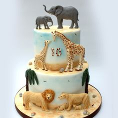 a three tiered cake with an elephant and giraffe on top