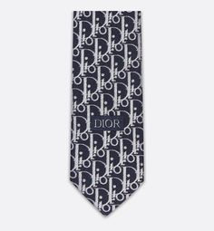 The navy blue silk tie presents the white Dior Oblique motif, embellished with white and gray jacquard stripes. Elegant and sophisticated, the tie lends a graphic touch to any suit.. Luxury Business Suit And Tie Accessories, Elegant White Ties For Work, Elegant White Ties For Workwear, Gray Silk, Silk Ties, Navy Blue, Dior, Stripes, Navy