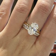 a woman's hand with two wedding rings on it and an engagement ring in the middle