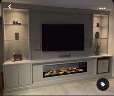 an entertainment center with built - in fireplace and shelves