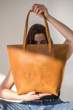 The most eye-catching tote ever! Exclusive sunflower hot embossing at leather tote. DETAILS: * Antique grain leather. * One roomy zipped compartment. * Soft and sturdy cotton lining. * Author's Sunflower hot embossing . COMPARTMENTS AND POCKETS: * External jetted pocket with zip on the bag's back side; * Inside: - jetted pocked with zip; - patch pocket with zip; - mini compartment between two pockets above; - simple patch pocket. Fits lots of stuff and laptop up to 13'', sport shoes and bottle o Embossed Tote Bag For Travel, Embossed Bags With Double Handle For Daily Use, Embossed Leather Bag With Double Handle, Embossed Double Handle Bag For Daily Use, Leather Double Handle Embossed Bag, Daily Use Embossed Bags With Double Handle, Embossed Double Handle Shoulder Bag For Everyday Use, Double Handle Embossed Shoulder Bag For Daily Use, Embossed Double Handle Shoulder Bag