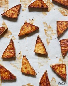 several pieces of pizza sitting on top of a piece of parchment paper covered in grease