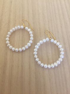 "Hoop earrings are always fun, and certainly kicked up a notch when the hoops are covered in pearls! 14K gold plated sterling silver wire is used to form the hoops. Luscious 4-4.5mm white cultured freshwater pearls circle up for a fun and flirty or dressy and classic earring. Approximate diameter is 1.25\". Gold plated sterling silver French ear wire settings allow the hoops to dangle freely. Handmade in Charleston SC, single person small business" White 14k Gold Filled Hoop Jewelry, White Pearl Drop Hoop Earrings In 14k Gold, Handmade Pearl Yellow Gold Hoop Earrings, Pearl Small Hoop Earrings With Ear Wire, Small Hoop Pearl Earrings With Ear Wire, White Pearl Charm Hoop Earrings, White Small Hoop Pearl Chain Jewelry, Handmade Yellow Gold Pearl Hoop Earrings, White Hoop Pearl Chain Jewelry