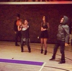 several people standing on a basketball court with one person holding a frisbee in the air