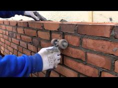 a man is working on a brick wall