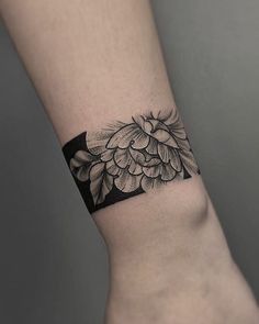 a black and white flower tattoo on the wrist