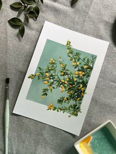 an image of some yellow flowers on a table with paintbrushes and watercolors