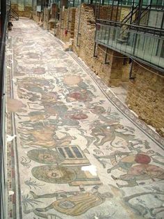 an ancient mosaic floor in the middle of a building