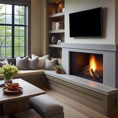 a living room filled with furniture and a flat screen tv mounted on the wall above a fire place