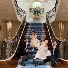 a group of people sitting on top of a stair case in front of a staircase