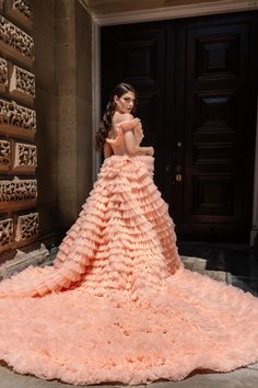 a woman in a pink dress is standing on the floor with her arms around her waist