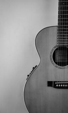 a black and white photo of an acoustic guitar, taken from the neck up to the fret