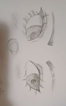 three drawings of different eyes on a white wall