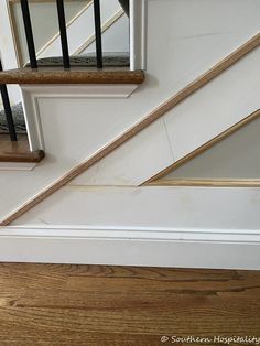 the bottom half of a stair case with wood flooring and metal handrails