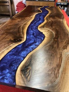 the table is made out of wood and has a blue stream running down it's side