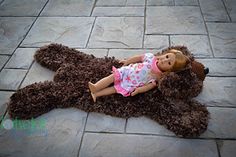 a doll laying on top of a teddy bear rug