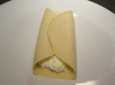 a piece of cheese on a white plate